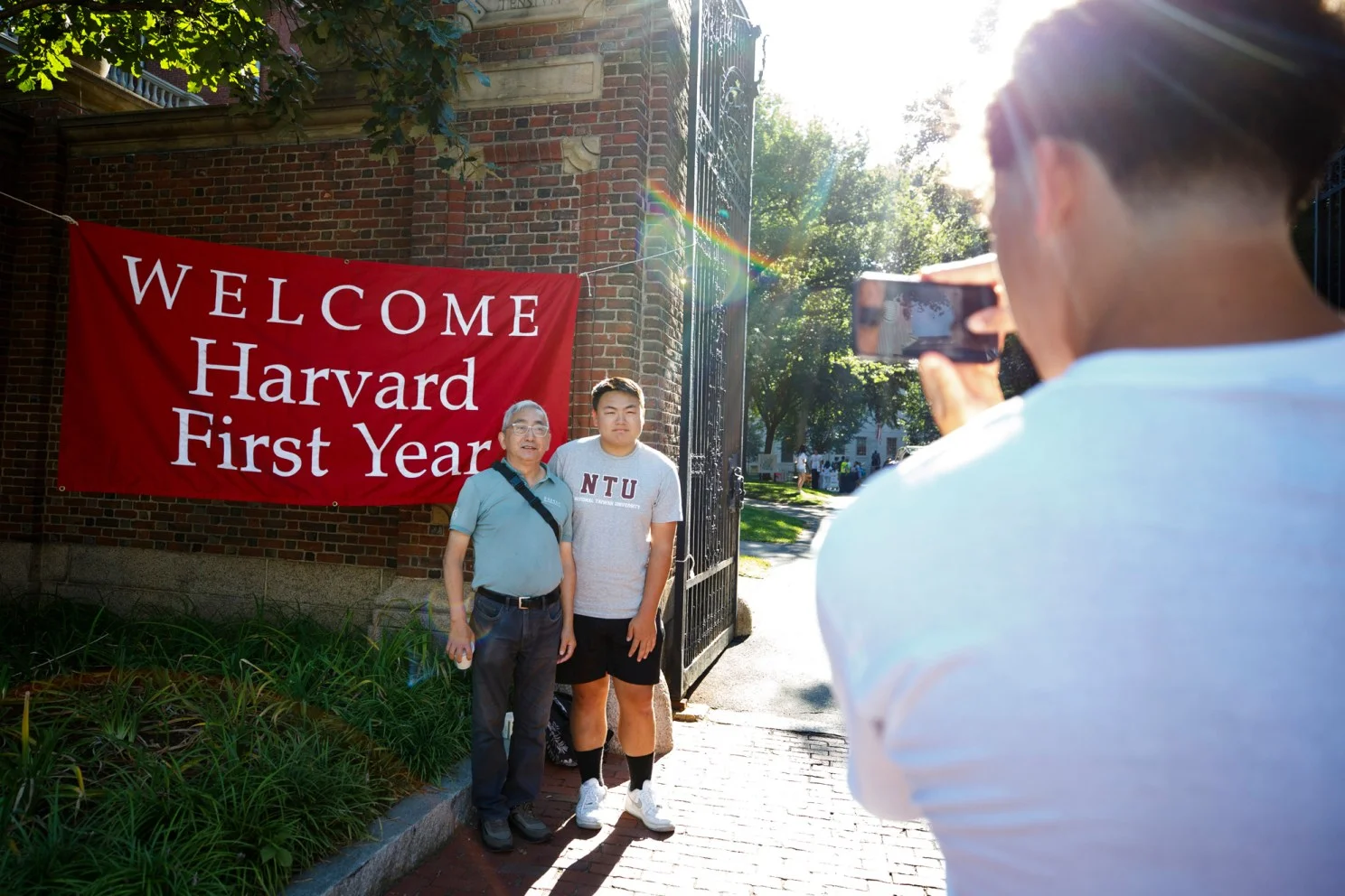 Dad and son pose infront of a "WELCOME Harvard First Years."